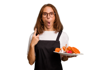 Young caucasian woman holding a waffles dish isolated having some great idea, concept of creativity.