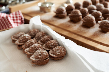 Placing homemade Christmas cookies in the form of nuts in a box