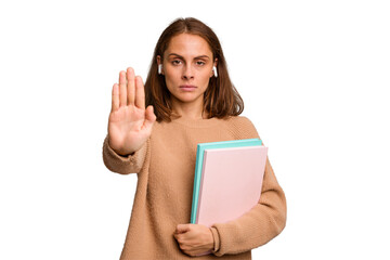 Naklejka premium Young student woman holding a books isolated standing with outstretched hand showing stop sign, preventing you.