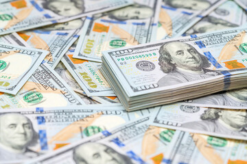 Stack of 100 dollars bills on a money background. American cash. Finance and economy concepts.