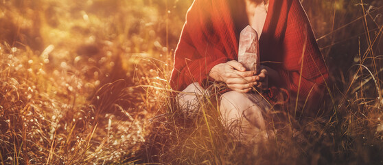 Beautiful shaman woman in nature and ceremony of the earth. Woman holding a large crystal of rosary...