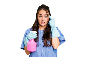 Young cleaner caucasian woman isolated on green chroma background showing a disappointment gesture with forefinger.