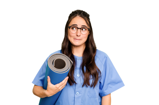 Young caucasian physiotherapist woman holding a mat isolated isolated on green chroma background confused, feels doubtful and unsure.