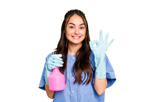 Young cleaner caucasian woman isolated on green chroma background cheerful and confident showing ok gesture.