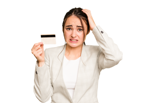 Young caucasian woman holding a credit card isolated on green chroma background being shocked, she has remembered important meeting.