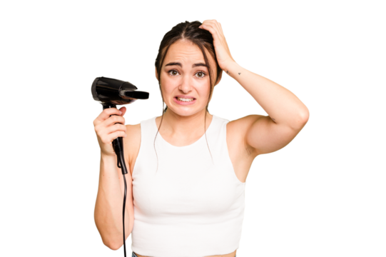 Young caucasian woman holding a hairdryer on green chroma background being shocked, she has remembered important meeting.