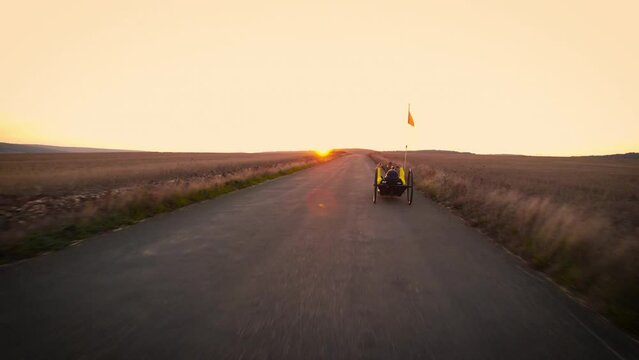 Scenic Shot of a Young Man Athlete with disability Riding a Handcycle. Adaptive Exercise Outdoors at Sunset . High quality 4k footage