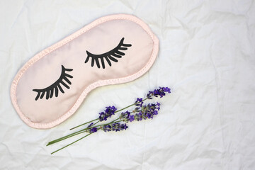 Sleep mask with natural lavender on a white sheet.