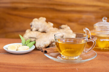 a cup of tea with ginger root, lime, cinnamon and teapot on white background. Health drink concept..