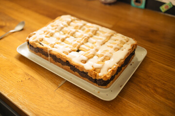 Homemade cake with poppy seeds, cream and zest in the form on a wooden table background
