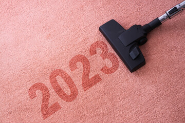2023 New year home cleaning with vacuum cleaner and copy space for a text