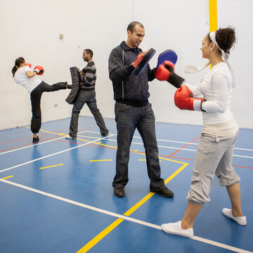 Sports Students: Kickboxing. Teenagers in their college gym under the supervision of their teachers. From a series of related images.