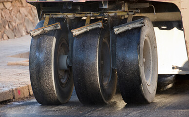 Road construction equipment coating asphalt black top lane