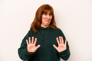 Middle age caucasian woman isolated on white background rejecting someone showing a gesture of...