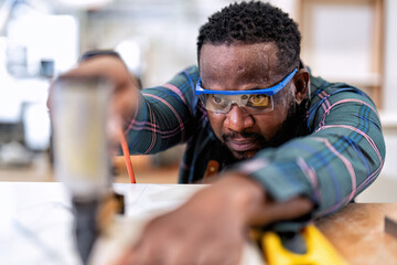 In work place carpenter man concentrate working using pneumatic nail gun drive nail to the wood