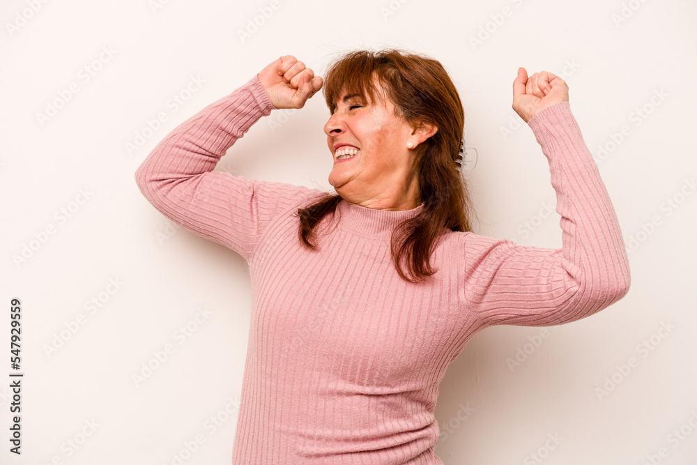 Wall mural Middle age caucasian woman isolated on white background celebrating a special day, jumps and raise arms with energy.