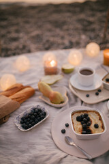 Romantic picnic by the sea at sunset.