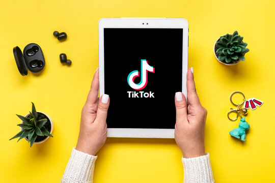 Bangkok, Thailand. October 2022 Tablet Tik Tok application icon, logo on screen and wireless headphones on colorful background Trendy social media network concept Flat lay Top view