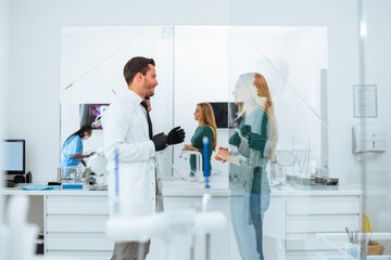 Oral surgeon talking to patient in office.