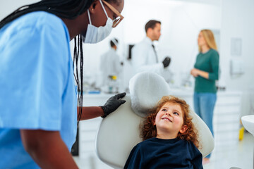 Cheerful child with assistant at dentist.