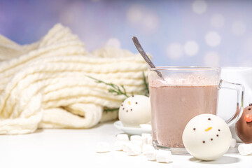 Making winter hot drink, preparation funny Christmas characters with hot chocolate bomb. Homemade hot chocolate cocoa balls made with Christmas snowman, reindeer, snowflake decor