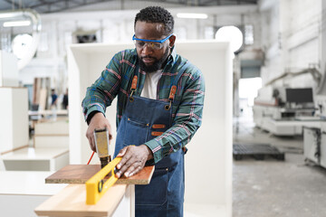 African American carpenter work at wood factory
