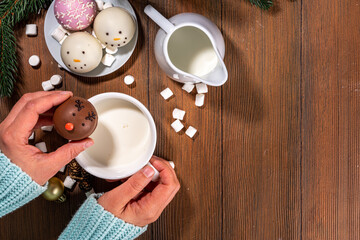 Making winter hot drink, preparation funny Christmas characters with hot chocolate bomb. Homemade hot chocolate cocoa balls made with Christmas snowman, reindeer, snowflake decor