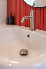 Modern stainless steel faucet or water tap and white ceramics wash basin decoration in the bathroom interior for home and living.