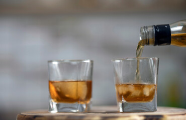Male hand pouring whiskey into a glass
