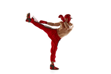Young professional kickboxer wearing helmet and boxing gloves in motion isolated on white...