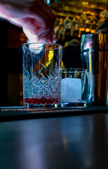 woman hand bartender making negroni cocktail in bar