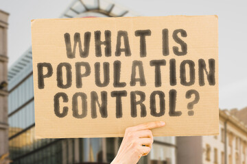 The question " What is Population Control? " is on a banner in men's hands with blurred background. Teamwork. Market. Economy. Global. Grow. Job. Network. Personnel. Progress. Resource. Trend. Group
