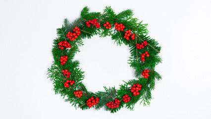 Fototapeta na wymiar Natural branches of spruce and arborvitae are decorated with red rowan berries. Eco friendly Christmas wreath.