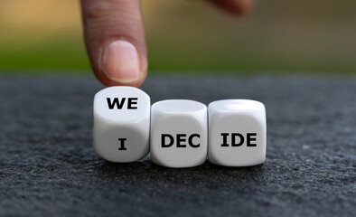 Hand turns dice and changes the expression 'I decide' to 'we decide'.