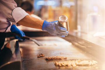 Hand of man take cooking of meat with vegetable grill, Chef cooking wagyu beef in Japanese teppanyaki restaurant