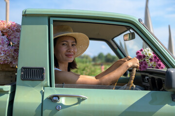 Plakat Beautiful young happy smiling woman driving her car and flower