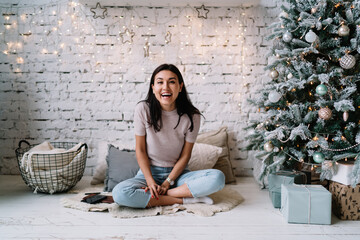 Fototapeta na wymiar Chinese girl sitting near Christmas tree at home