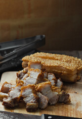 crispy pork belly deep fried pork or Chinese roasted pork belly on a wooden chopping board. close-up shot