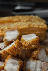 crispy pork belly deep fried pork or Chinese roasted pork belly on a wooden chopping board. close-up shot