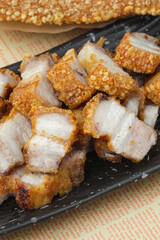 crispy pork belly deep fried pork or Chinese roasted pork belly on a wooden chopping board. close-up shot