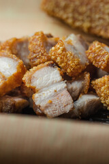 crispy pork belly deep fried pork or Chinese roasted pork belly on a wooden chopping board. close-up shot