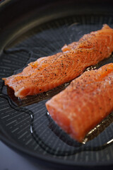 Salmon fried in olive oil. Frying pan for frying salmon in the kitchen. Shallow depth of field