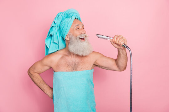 Photo of funny senior man sing in bath use shower head as microphone isolated on pastel color background