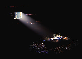Bright light from the window illuminates the baby Jesus in the manger, Christmas and Christmas...