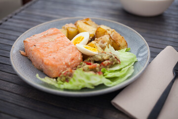 steamed salmon fillet with potato wedges, guacamole homemade and quail egg