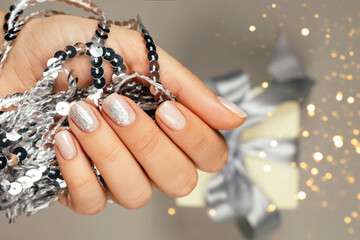Festive manicure on a gray background with sparkles.