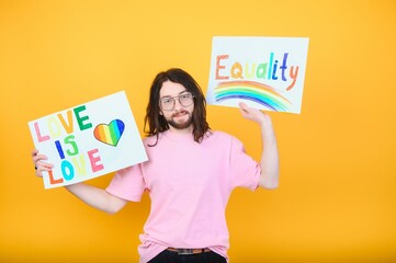 Attractive gay caucasian man holding a protest sign during a LGBT pride parade. Equality.