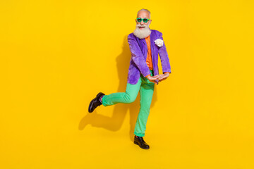 Full size portrait of positive cheerful granddad have good mood chilling isolated on yellow color background