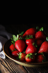 A bowl with ripe bright strawberry in rustic style