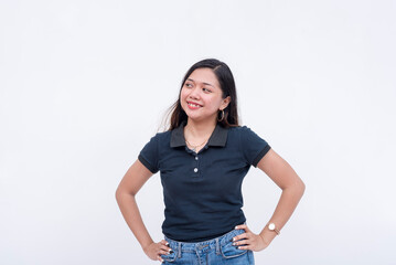 A pretty young Filipina intern in a dark blue polo shirt and jeans looking to the left. Isolated on a white background.